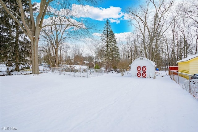 yard covered in snow with an outbuilding