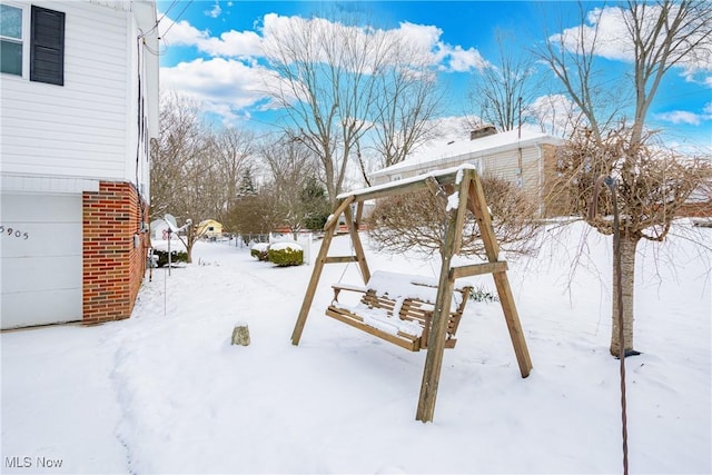 snowy yard with a garage