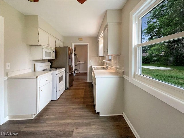 kitchen with white cabinets, white appliances, dark hardwood / wood-style floors, and sink