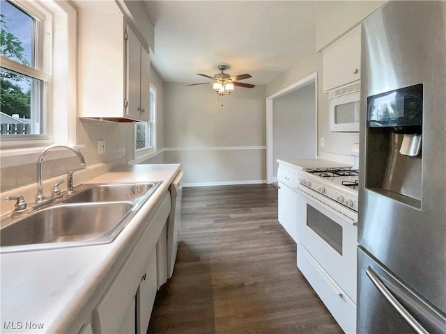 kitchen with white appliances, sink, ceiling fan, dark hardwood / wood-style flooring, and white cabinetry