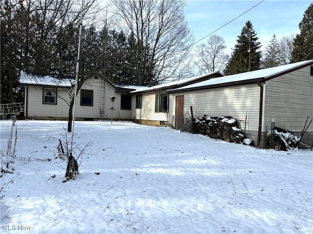 view of snow covered back of property