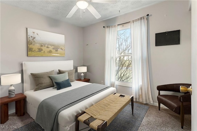 carpeted bedroom with ceiling fan and a textured ceiling