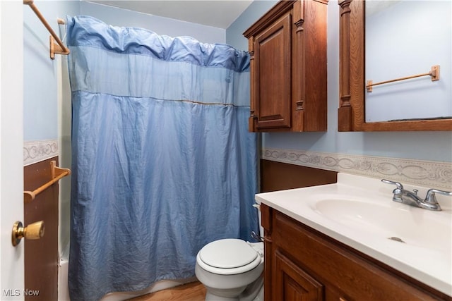 bathroom featuring a shower with curtain, hardwood / wood-style flooring, vanity, and toilet