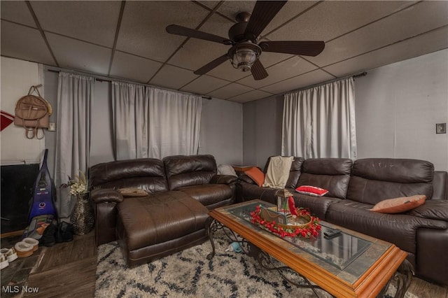 living room with hardwood / wood-style flooring, a drop ceiling, and ceiling fan