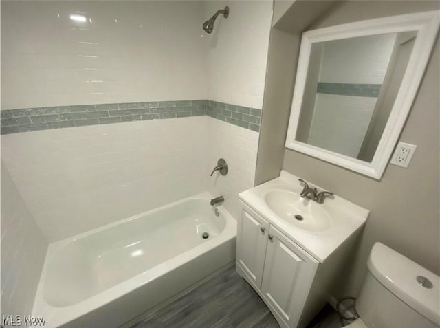 full bathroom with hardwood / wood-style floors, vanity, shower / bath combination, and toilet