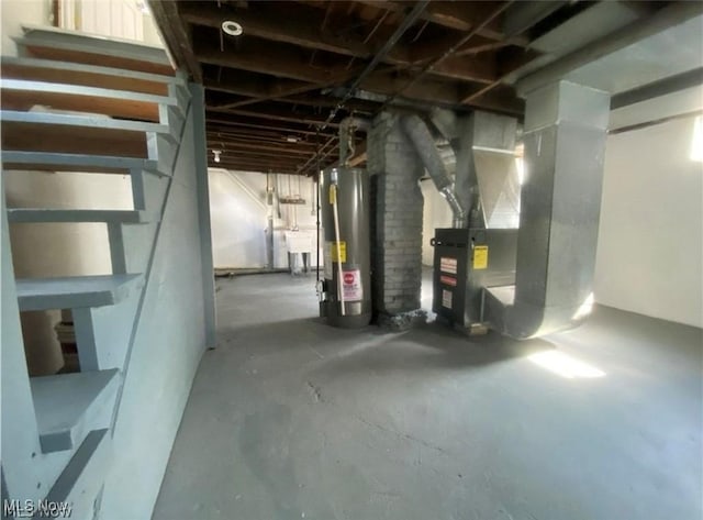 basement featuring sink, heating unit, and water heater