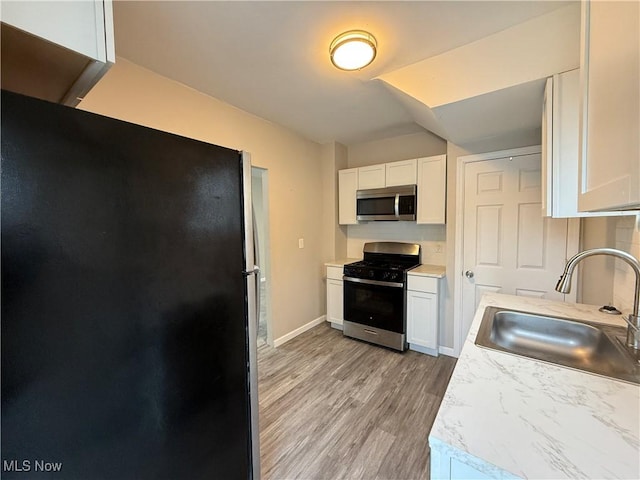 747 Brownell Ave, Lorain, OH 44052 - kitchen with white cabinets, a sink, stainless steel appliances, and light countertops