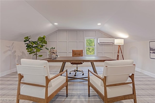 office space featuring a wall mounted air conditioner, light colored carpet, and lofted ceiling