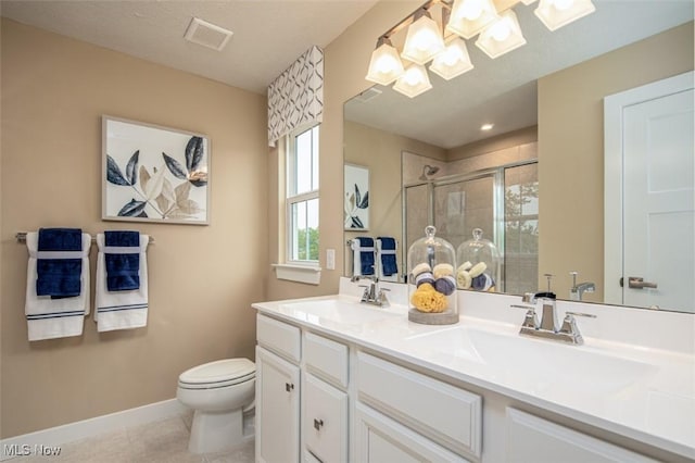 bathroom featuring tile patterned flooring, vanity, toilet, and a shower with shower door