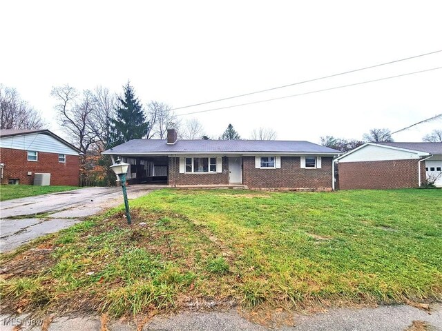 ranch-style home with a carport, a front yard, and central AC