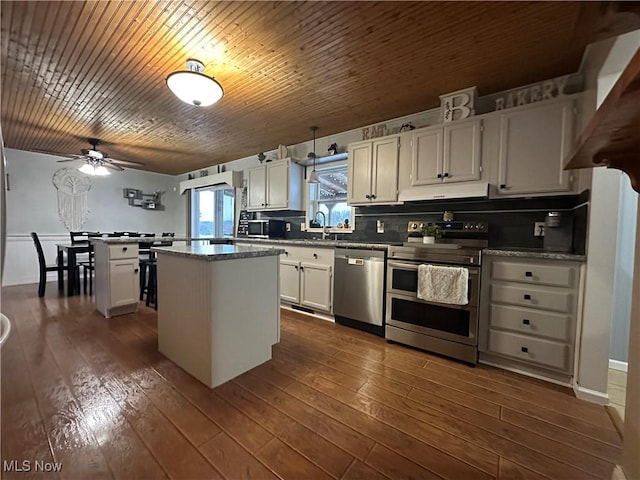 kitchen featuring tasteful backsplash, white cabinetry, a center island, and stainless steel appliances