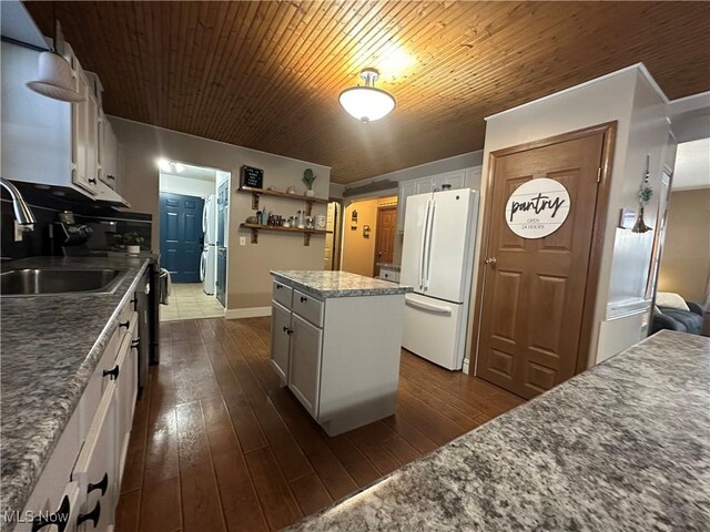 kitchen featuring white fridge, white cabinetry, and sink