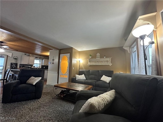 living room with wood ceiling, ceiling fan, and a healthy amount of sunlight