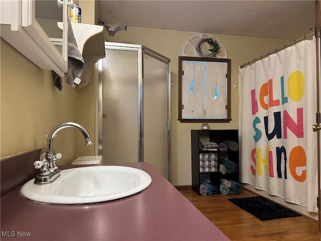 bathroom with a shower, hardwood / wood-style floors, vanity, and a textured ceiling