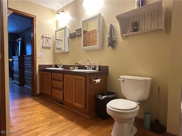 bathroom featuring wood-type flooring, vanity, and toilet