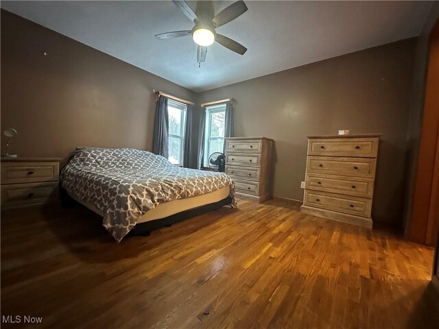 bedroom with ceiling fan and dark hardwood / wood-style flooring