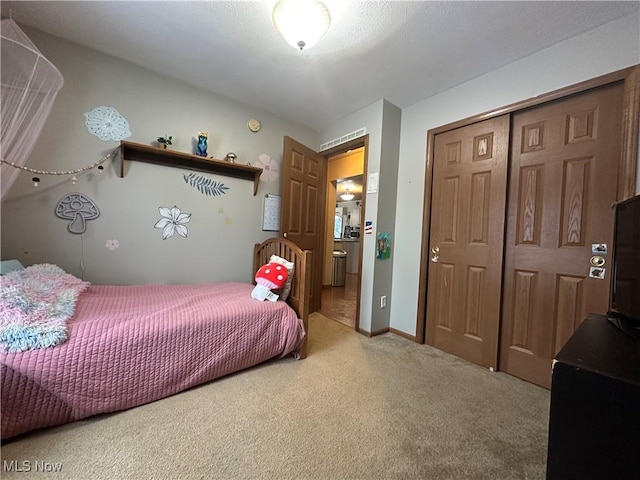 bedroom featuring carpet flooring, ensuite bathroom, and a closet