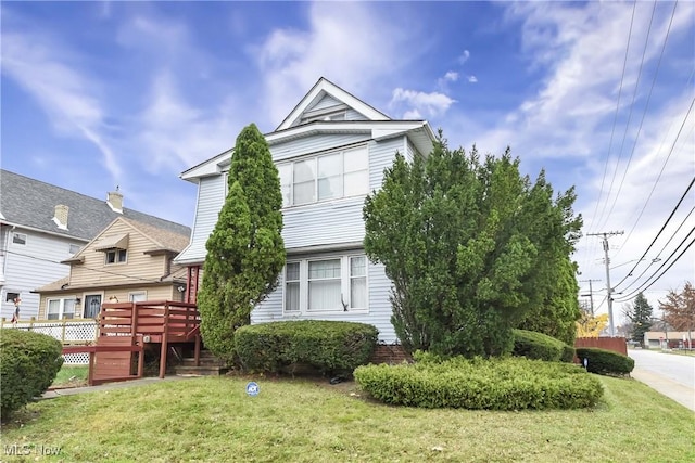 exterior space with a wooden deck and a front yard