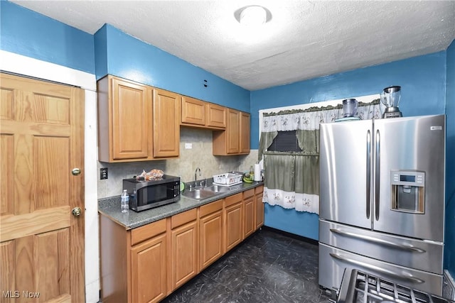 kitchen with decorative backsplash, a textured ceiling, stainless steel appliances, and sink