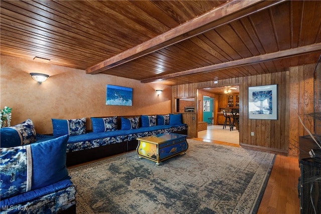 living room with wood walls, beamed ceiling, wooden ceiling, and wood-type flooring