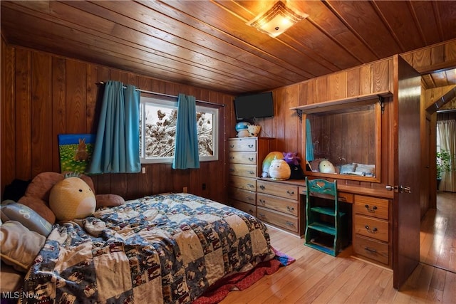 bedroom with wood walls, wood ceiling, and light hardwood / wood-style flooring