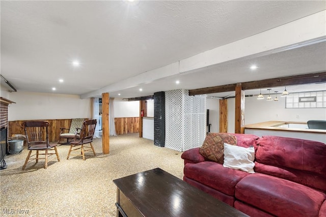 carpeted living room featuring wood walls and a brick fireplace