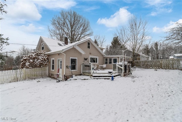 snow covered rear of property featuring a deck