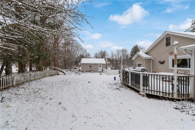 snowy yard featuring a wooden deck