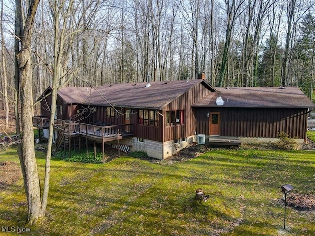 view of front of home with central AC unit, a front lawn, and a wooden deck