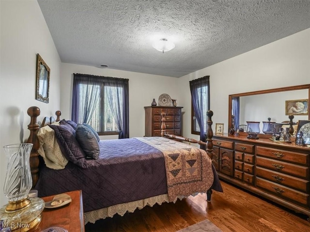 bedroom with a textured ceiling and hardwood / wood-style flooring