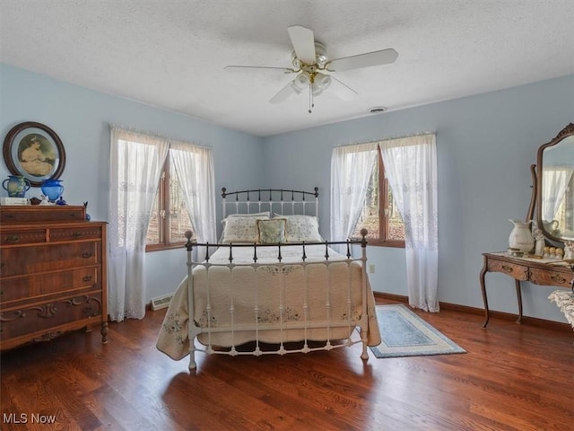 bedroom featuring a textured ceiling, ceiling fan, and dark hardwood / wood-style flooring