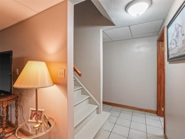 interior space with light tile patterned flooring and a paneled ceiling