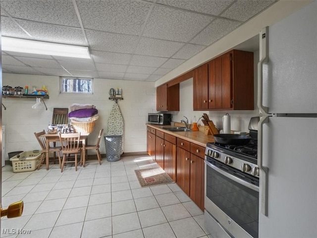 kitchen with sink, light tile patterned flooring, and appliances with stainless steel finishes