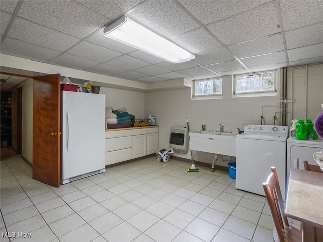 laundry room with sink, washing machine and dryer, cabinets, and heating unit