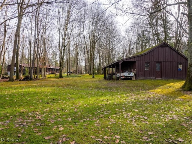 view of yard with a carport and an outbuilding