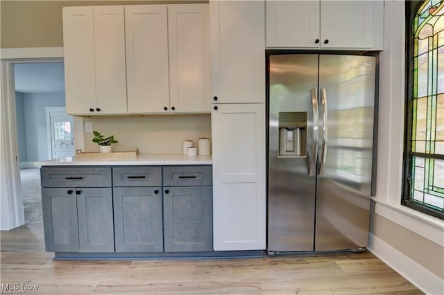 kitchen featuring gray cabinetry, stainless steel fridge, and a healthy amount of sunlight