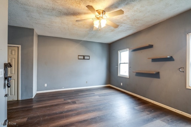 spare room with ceiling fan, dark wood-type flooring, and a textured ceiling