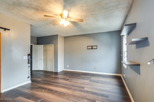 spare room with dark hardwood / wood-style flooring, a textured ceiling, and ceiling fan