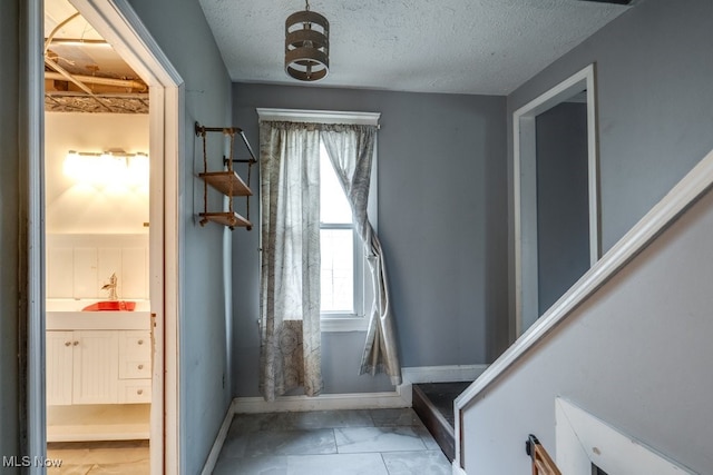 interior space featuring sink and a textured ceiling