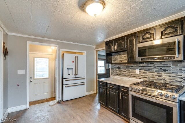 kitchen featuring tasteful backsplash, light wood-type flooring, dark brown cabinets, appliances with stainless steel finishes, and ornamental molding