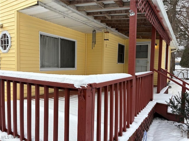 snow covered property with a wooden deck