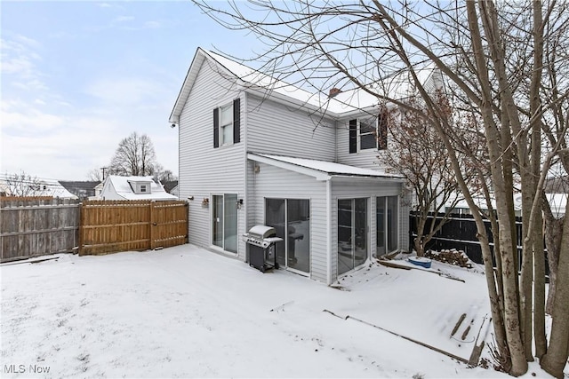 view of snow covered back of property