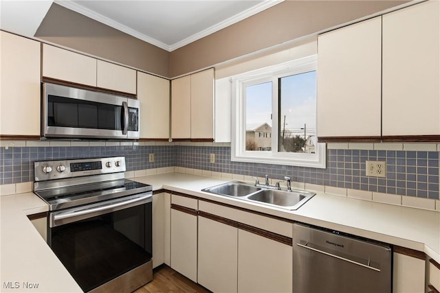 kitchen with tasteful backsplash, sink, white cabinets, and stainless steel appliances