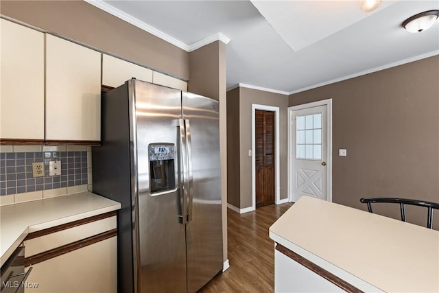 kitchen with white cabinetry, stainless steel appliances, dark hardwood / wood-style flooring, decorative backsplash, and ornamental molding