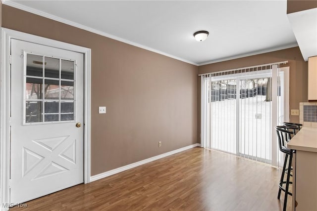 unfurnished dining area featuring wood-type flooring and ornamental molding