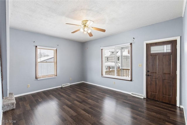 entryway featuring ceiling fan, a textured ceiling, and dark wood-type flooring