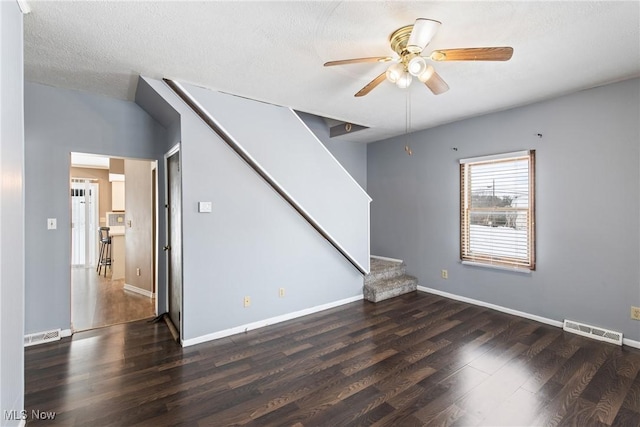 unfurnished living room featuring ceiling fan and dark hardwood / wood-style floors