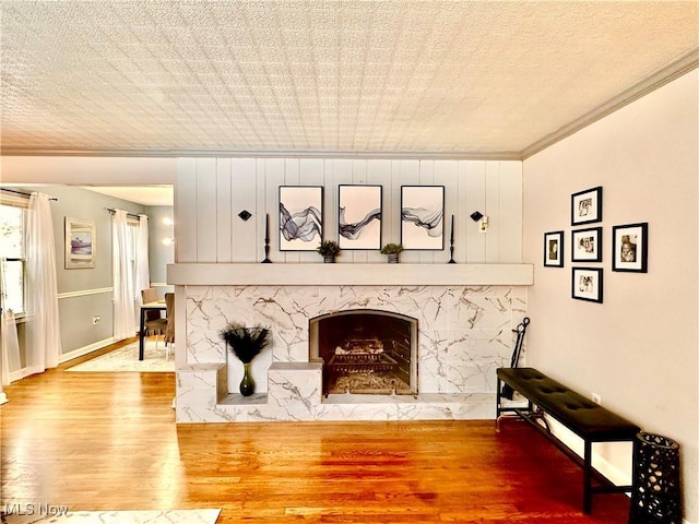 living room featuring a premium fireplace, hardwood / wood-style floors, and ornamental molding