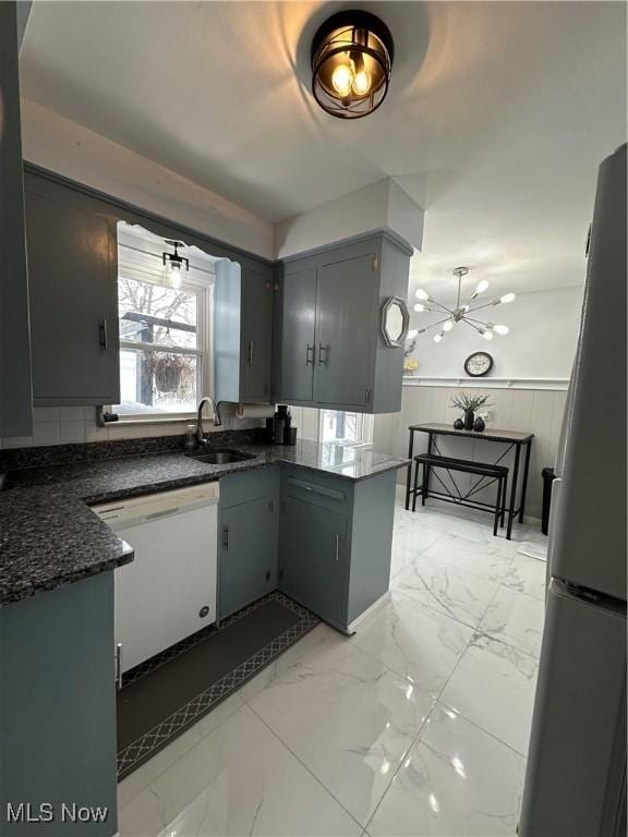 kitchen with dishwasher, refrigerator, gray cabinetry, and sink