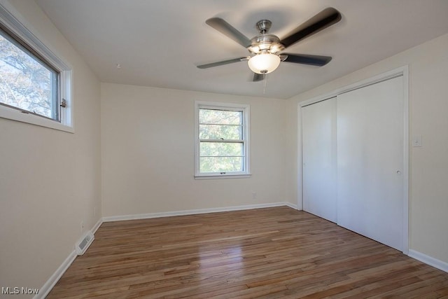 unfurnished bedroom with ceiling fan, a closet, and wood-type flooring